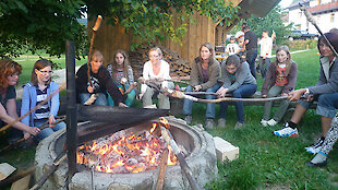 Gemütliches Lagerfeuer mit Stockbrot beim Bauernhofurlaub